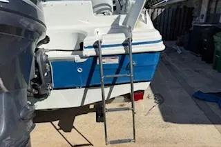 Slide: The Image of 2013 Hurricane SunDeck 187 OB boat with ladder, docked on a sunny day. - 7
