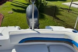 Slide: The Image of 2013 Hurricane SunDeck 187 OB boat with outboard motor, white and blue seating, in a grassy yard. - 8