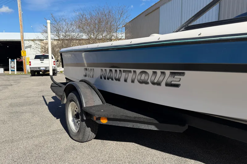 Slide: The Image of 1995 Correct Craft Ski Nautique boat on trailer, parked outdoors under clear sky. - 10