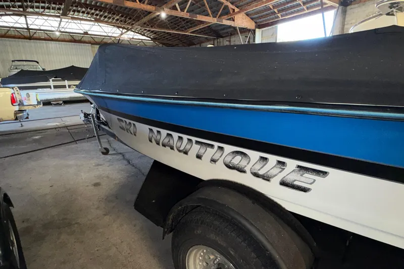 Slide: The Image of 1995 Correct Craft Ski Nautique boat with cover in a storage facility. - 14