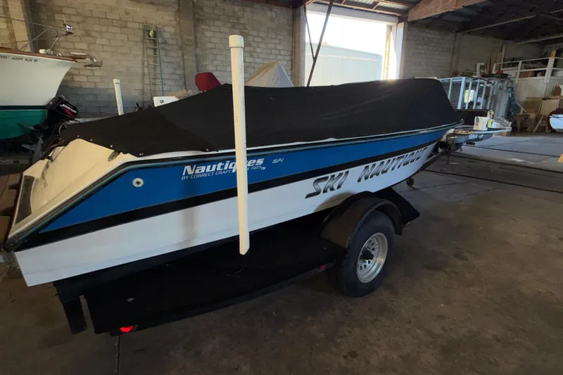 Slide: The Image of 1995 Correct Craft Ski Nautique boat with cover in a storage facility. - 17