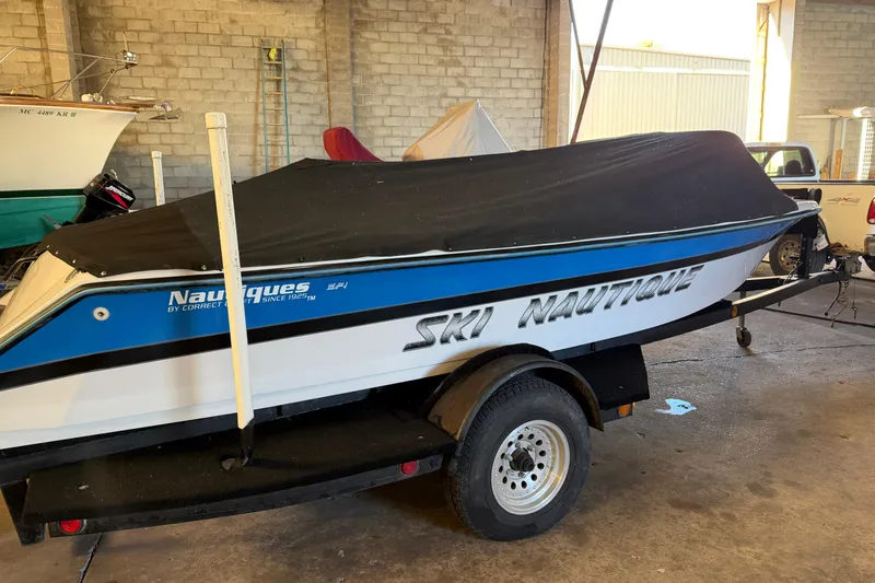 Slide: The Image of 1995 Correct Craft Ski Nautique boat with cover on trailer in garage. - 18