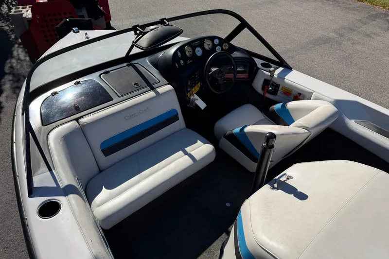 Slide: The Image of 1995 Correct Craft Ski Nautique boat interior with white and blue seating, dashboard, and steering wheel. - 21