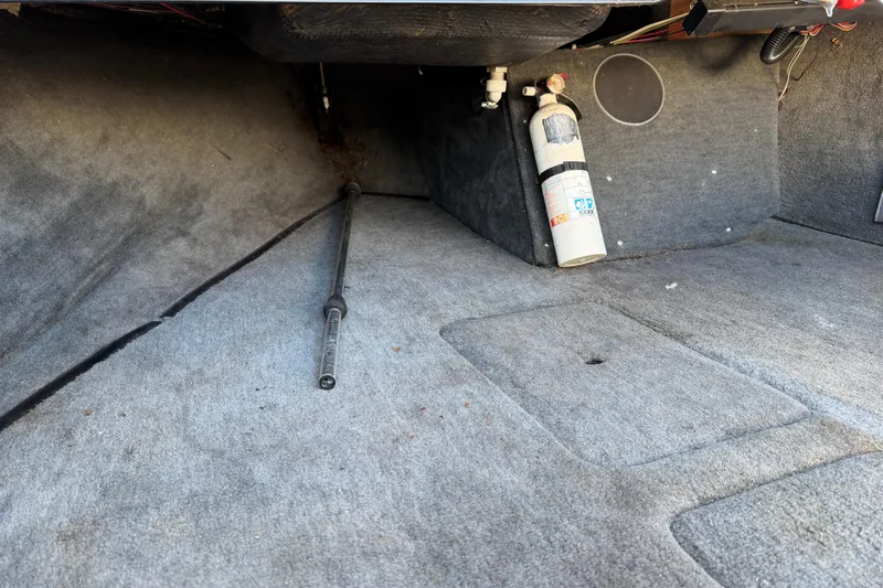 Slide: The Image of Interior of a 1995 Correct Craft Ski Nautique boat, featuring carpeted flooring and a fire extinguisher. - 25