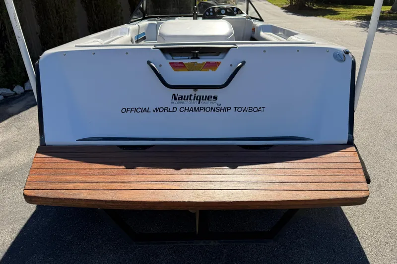 Slide: The Image of 1995 Correct Craft Ski Nautique boat, rear view, wooden platform, championship towboat branding. - 6