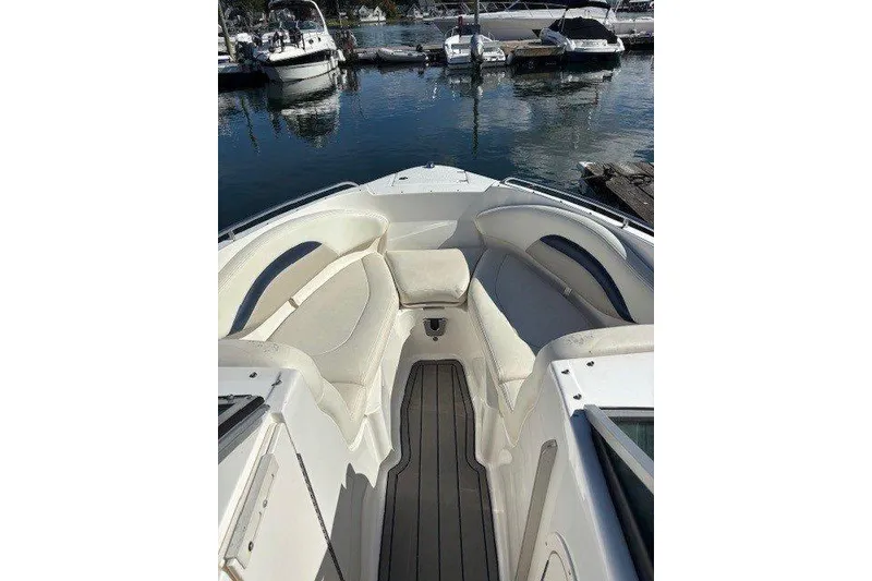 Slide: The Image of 2009 Chaparral 256 SSX boat interior with cushioned seating, docked at marina. - 4