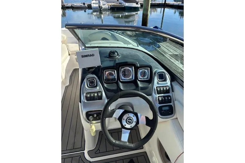 Slide: The Image of 2009 Chaparral 256 SSX boat dashboard with steering wheel and Simrad display. - 5