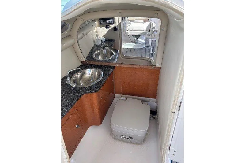 Slide: The Image of 2009 Chaparral 256 SSX boat interior with sink, mirror, and compact toilet. - 6