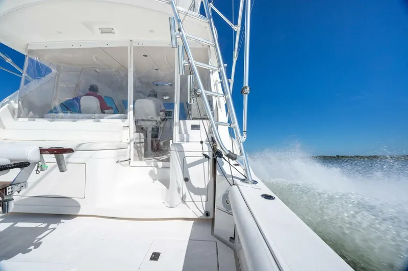 Slide: The Image of 2012 Cabo 40 Hardtop Express yacht cruising on open water under clear blue sky. - 10