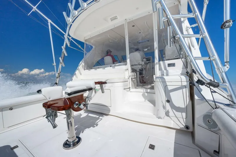 Slide: The Image of 2012 Cabo 40 Hardtop Express boat interior with fishing chair and ladder, cruising on open water. - 11