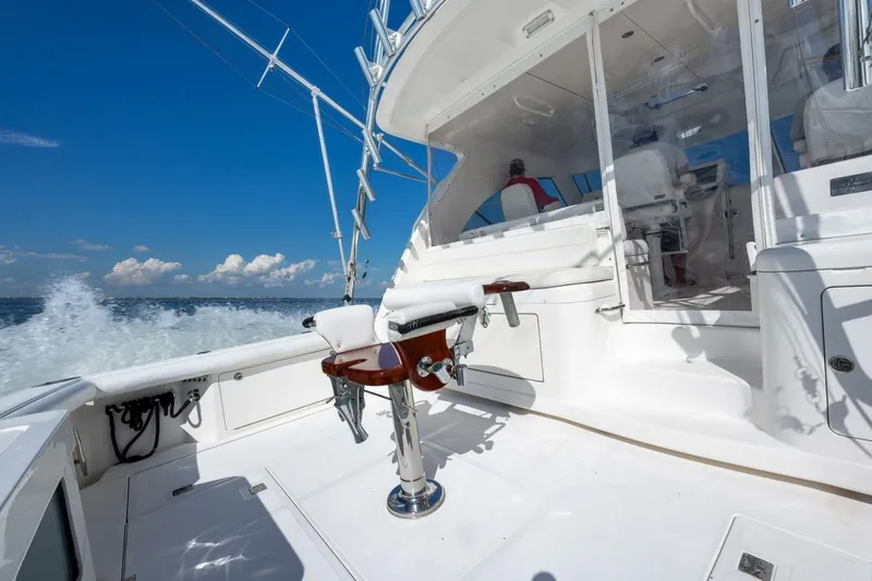 Slide: The Image of 2012 Cabo 40 Hardtop Express yacht cruising on open water, featuring a sleek white deck. - 13