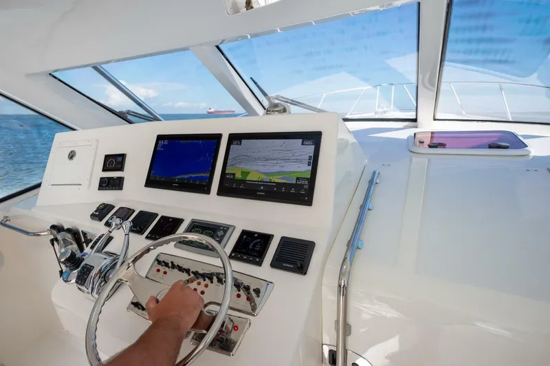 Slide: The Image of Helm of 2012 Cabo 40 Hardtop Express with navigation screens and controls. - 16