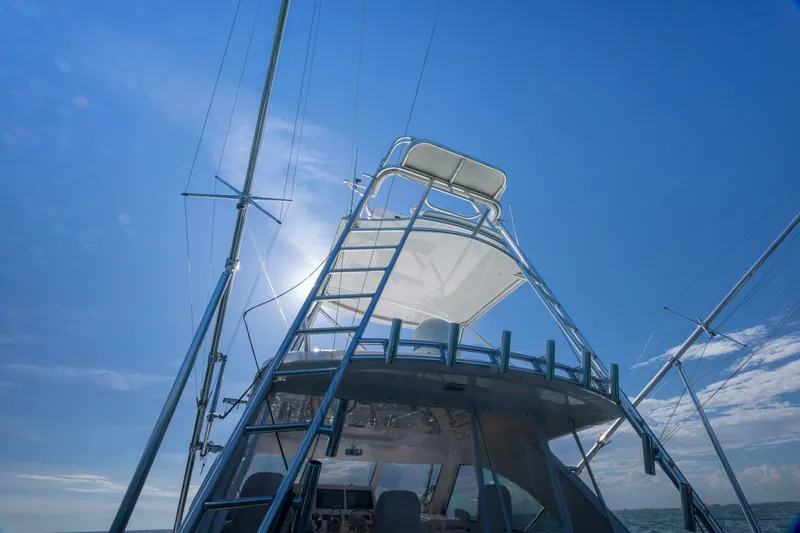 Slide: The Image of 2012 Cabo 40 Hardtop Express yacht under clear blue sky, viewed from below. - 17