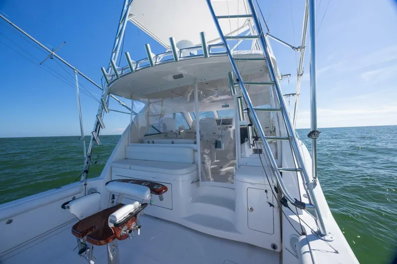 Slide: The Image of 2012 Cabo 40 Hardtop Express yacht on open sea, featuring fishing equipment and ladder. - 19