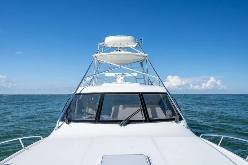 Slide: The Image of 2012 Cabo 40 Hardtop Express boat on open sea under clear blue sky. - 20