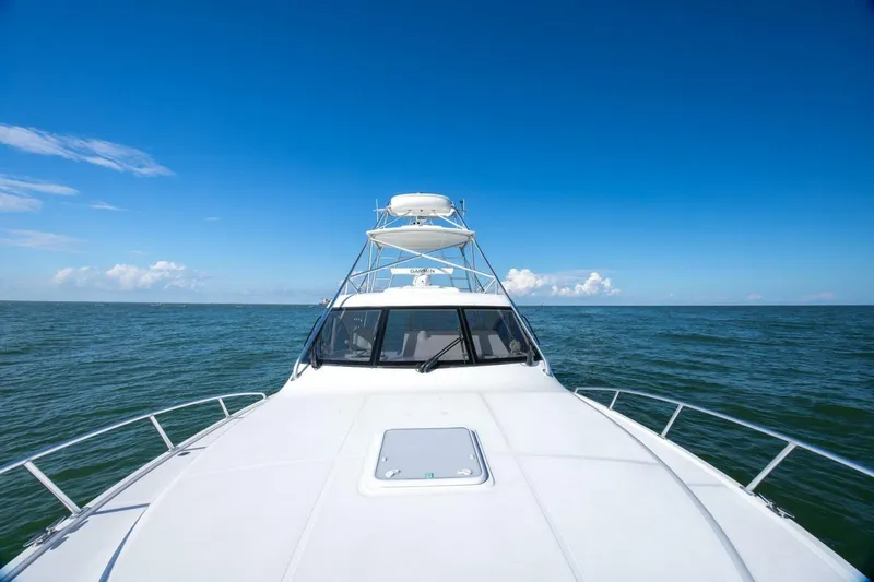 Slide: The Image of 2012 Cabo 40 Hardtop Express yacht cruising on open sea under clear blue sky. - 21
