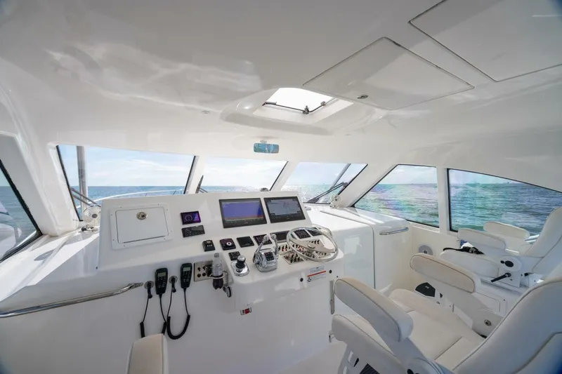 Slide: The Image of 2012 Cabo 40 Hardtop Express yacht helm with ocean view and modern controls. - 26