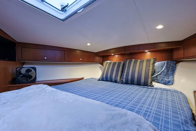 Slide: The Image of Luxurious cabin interior of 2012 Cabo 40 Hardtop Express with cozy bedding and ambient lighting. - 34