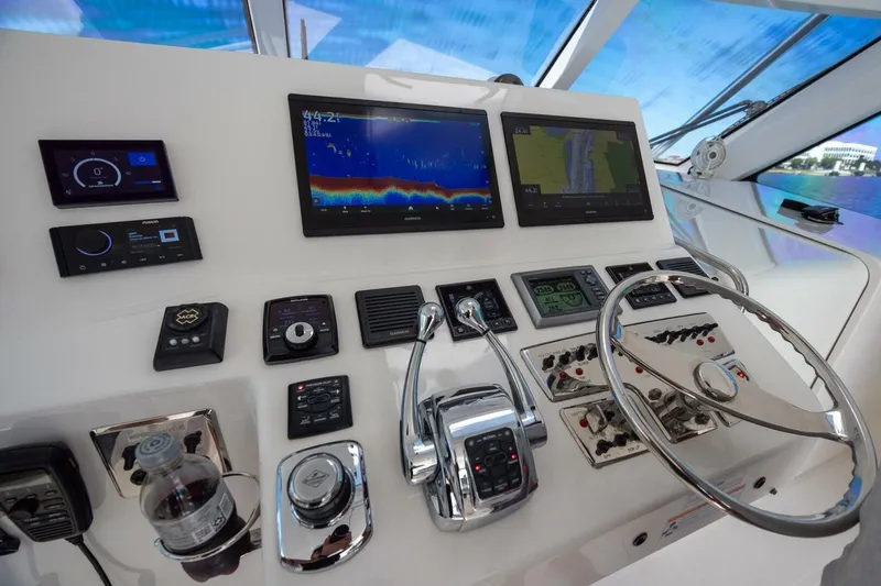 Slide: The Image of Control panel of 2012 Cabo 40 Hardtop Express yacht with navigation screens and steering wheel. - 4