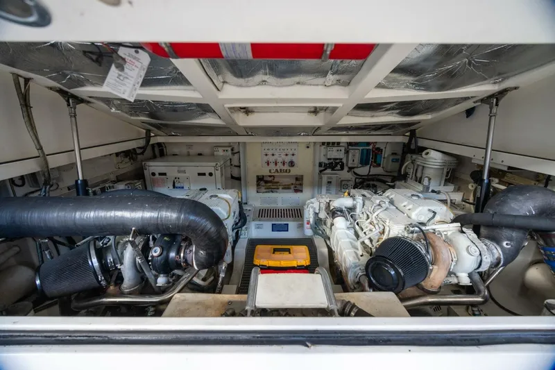 Slide: The Image of Engine room of 2012 Cabo 40 Hardtop Express, showcasing dual engines and mechanical components. - 40