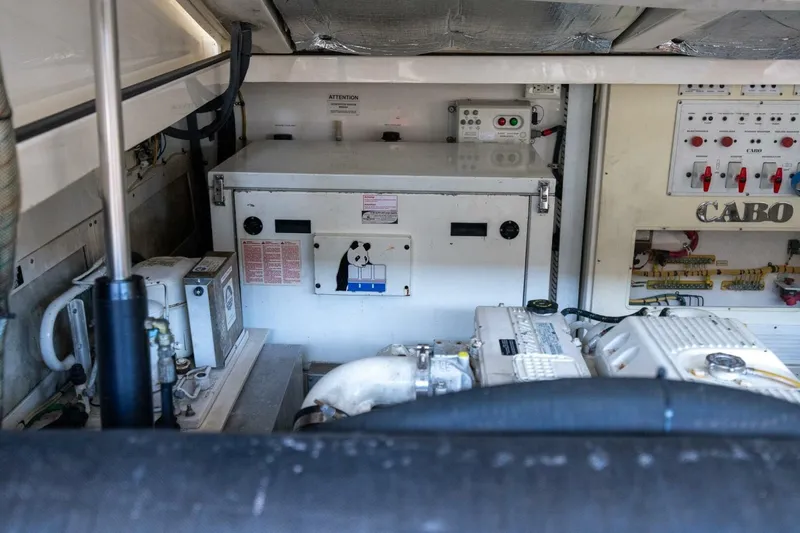 Slide: The Image of Engine room of 2012 Cabo 40 Hardtop Express with control panels and machinery. - 42