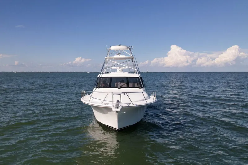 Slide: The Image of 2012 Cabo 40 Hardtop Express boat on open sea under blue sky. - 47