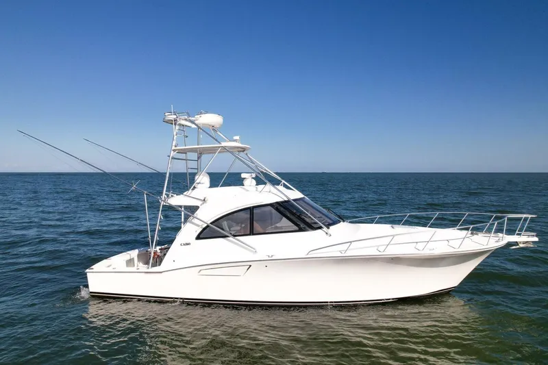 Slide: The Image of 2012 Cabo 40 Hardtop Express boat on open water under clear blue sky. - 49