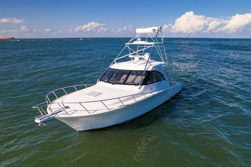 Slide: The Image of 2012 Cabo 40 Hardtop Express yacht cruising on open sea under clear skies. - 53