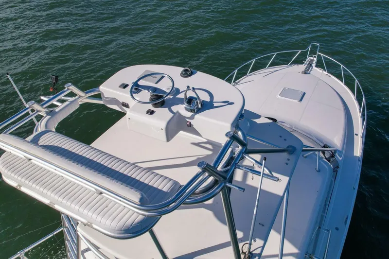 Slide: The Image of 2012 Cabo 40 Hardtop Express boat helm and bow on open water. - 56