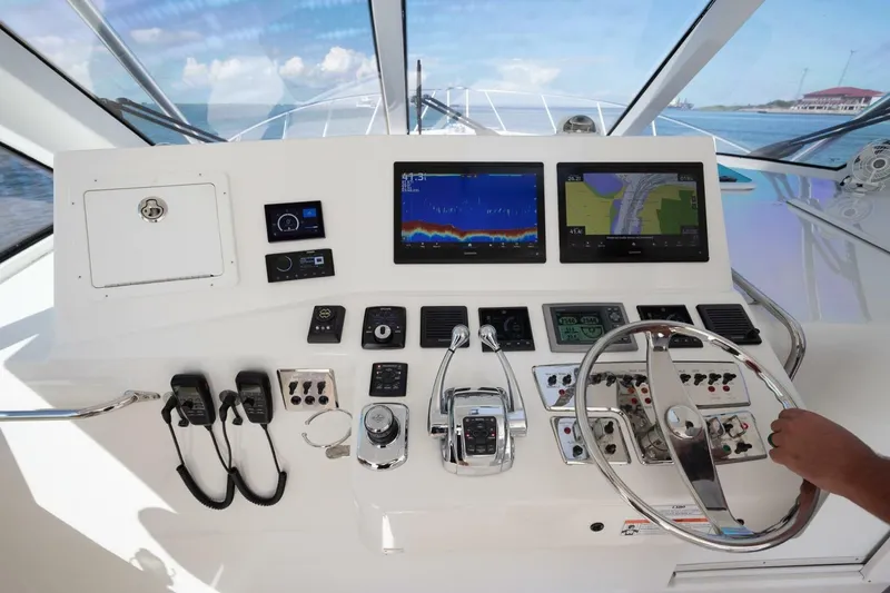 Slide: The Image of Helm of 2012 Cabo 40 Hardtop Express with navigation screens and controls. - 6