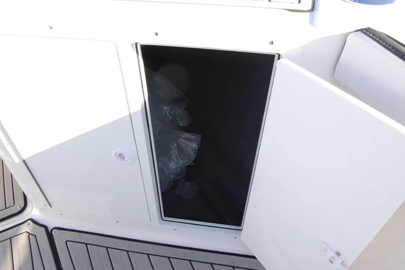 Slide: The Image of Open storage compartment on 2026 Yamaha Boats 222 FSH Sport E, featuring sleek design. - 11