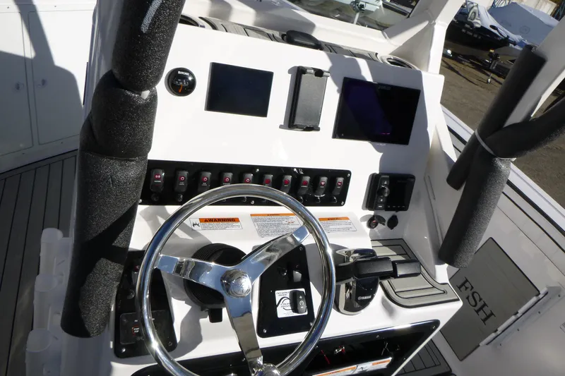 Slide: The Image of Control panel of 2026 Yamaha Boats 222 FSH Sport E, featuring steering wheel and gauges. - 14