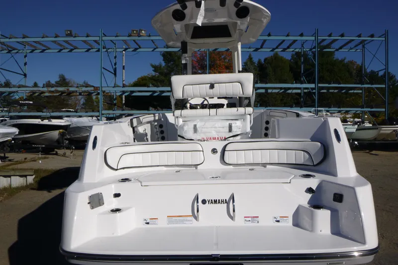 Slide: The Image of 2026 Yamaha Boats 222 FSH Sport E, rear view, in a boatyard setting. - 3