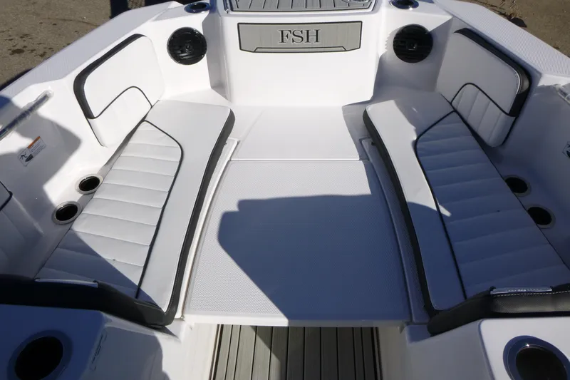 Slide: The Image of 2026 Yamaha Boats 222 FSH Sport E interior with white cushioned seating and cup holders. - 6