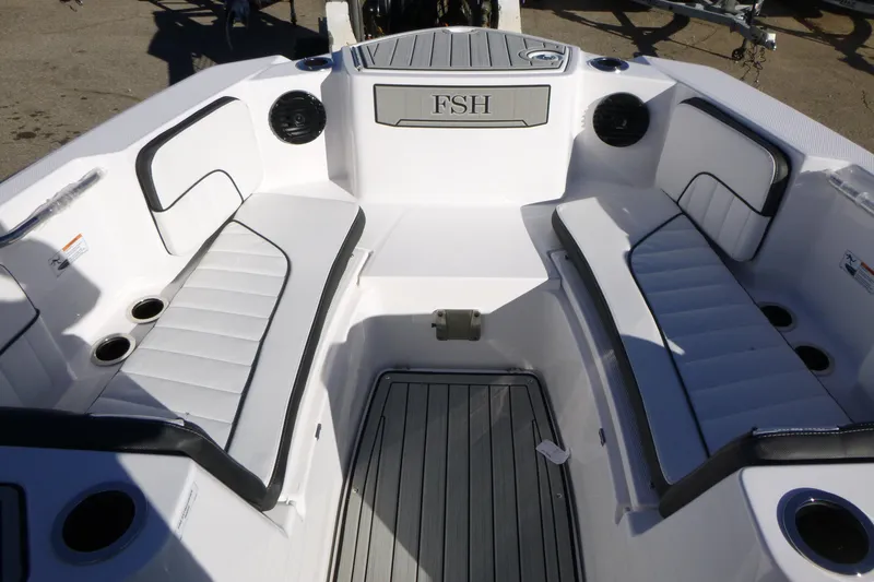 Slide: The Image of 2026 Yamaha Boats 222 FSH Sport E interior with white seating and cup holders. - 7