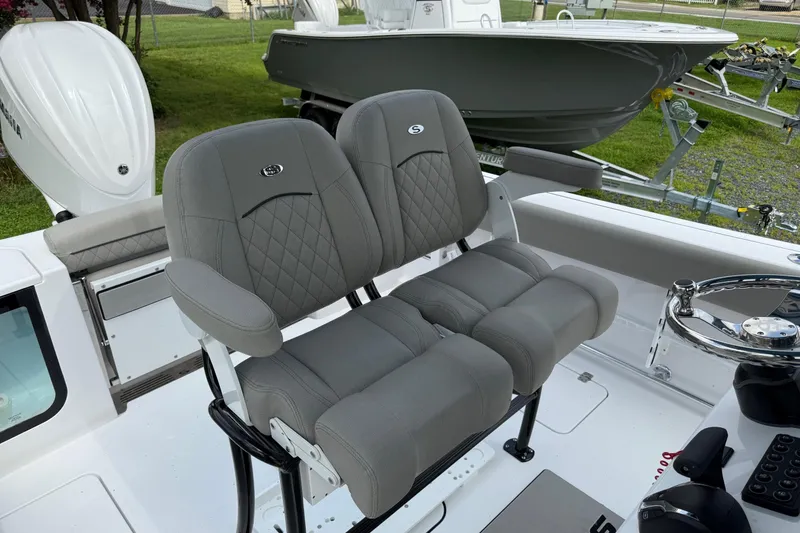 Slide: The Image of 2026 Sportsman Open 252 Center Console boat with gray cushioned seating and steering wheel. - 15