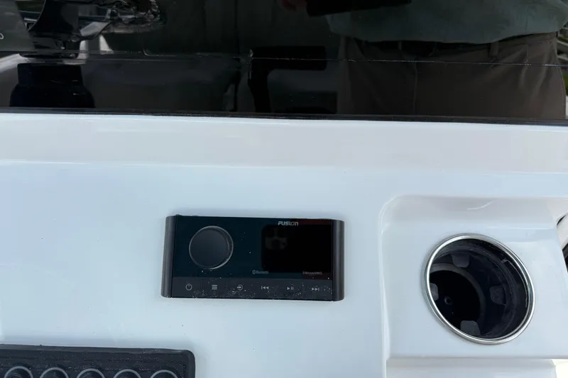 Slide: The Image of 2026 Sportsman Open 252 Center Console dashboard with Fusion stereo system and cup holder. - 17