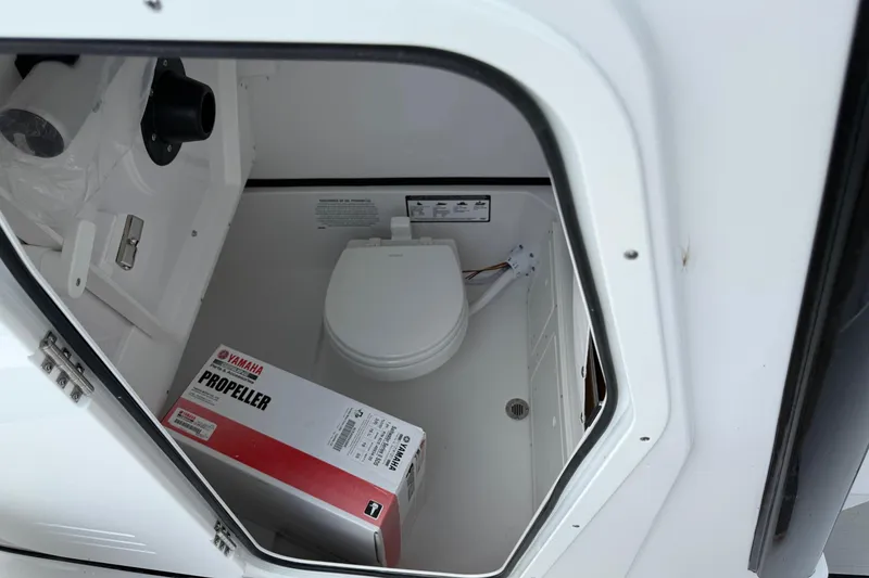 Slide: The Image of 2026 Sportsman Open 252 Center Console boat storage with toilet and Yamaha propeller box. - 19