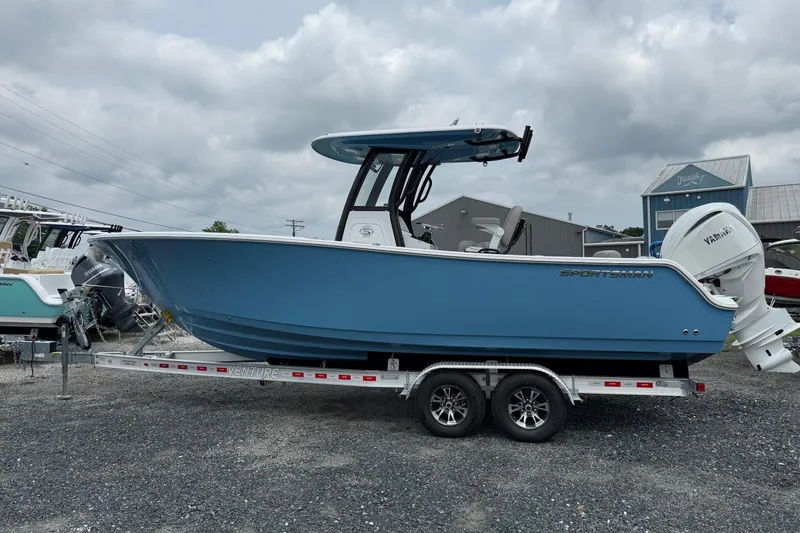 Slide: The Image of 2026 Sportsman Open 252 Center Console boat on trailer, blue hull, overcast sky. - 3