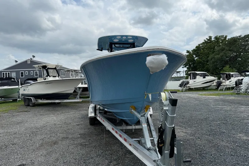 Slide: The Image of 2026 Sportsman Open 252 Center Console boat on trailer, parked outdoors under cloudy sky. - 7