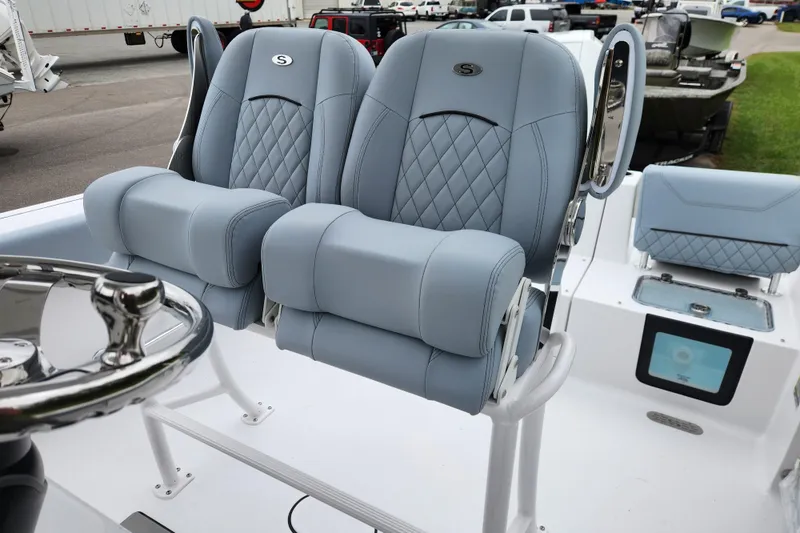 Slide: The Image of 2026 Sportsman Heritage 231 Center Console boat with luxurious blue seating and steering wheel. - 19