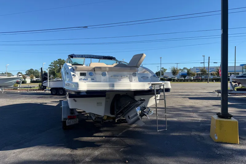 Slide: The Image of 2012 Chaparral 246 SSi boat parked outdoors, rear view with ladder and outboard motor. - 2