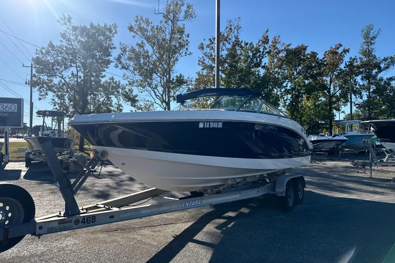 Slide: The Image of 2012 Chaparral 246 SSi boat on trailer, parked outdoors under clear blue sky. - 3