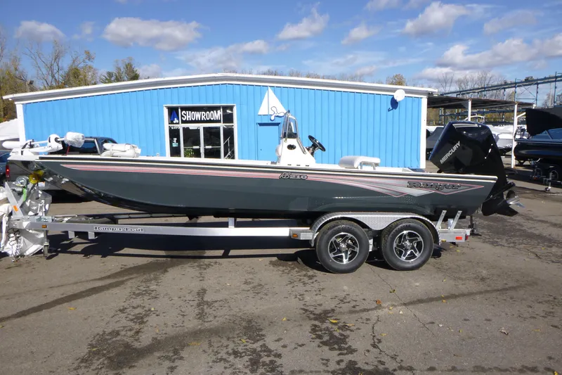 The Image of 2025 Ranger RB210 boat on trailer outside blue showroom building. - 1