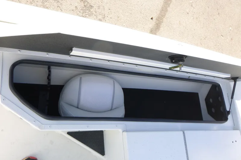 Slide: The Image of 2025 Ranger RB210 boat storage compartment with white interior and seat. - 11