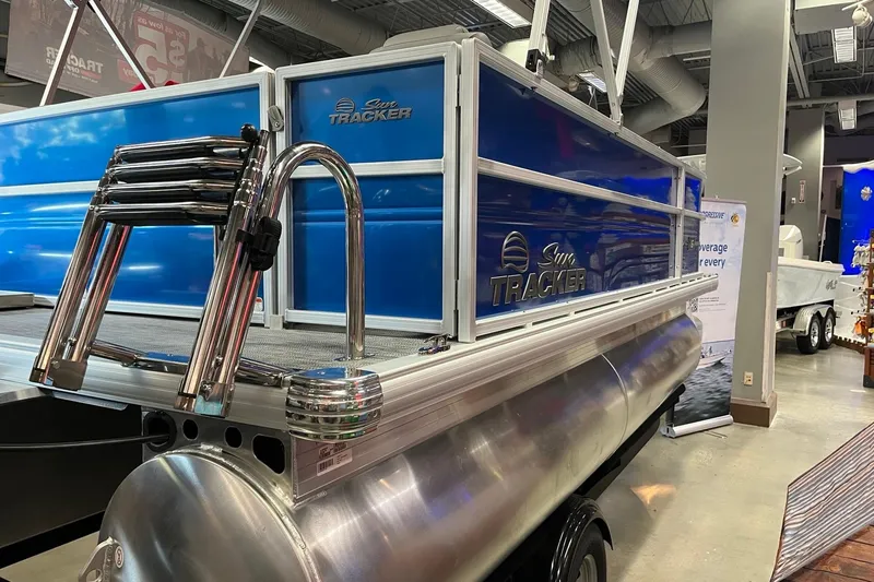 Slide: The Image of 2026 Sun Tracker Party Barge 16 DLX pontoon boat displayed indoors. - 3