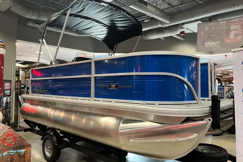 Slide: The Image of 2026 Sun Tracker Party Barge 16 DLX pontoon boat displayed indoors. - 2
