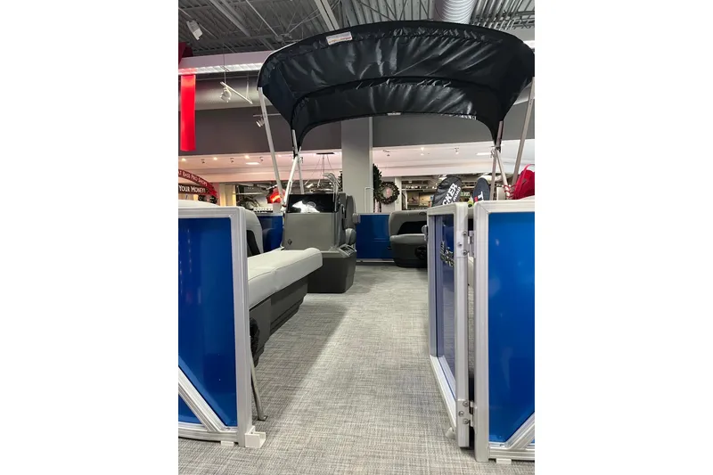 Slide: The Image of 2026 Sun Tracker Party Barge 16 DLX pontoon boat interior with canopy in showroom. - 4