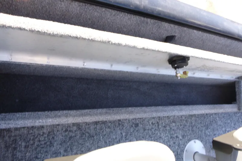Slide: The Image of Interior view of 2026 Tracker Pro Guide V-16 SC boat, featuring carpeted storage compartment. - 12