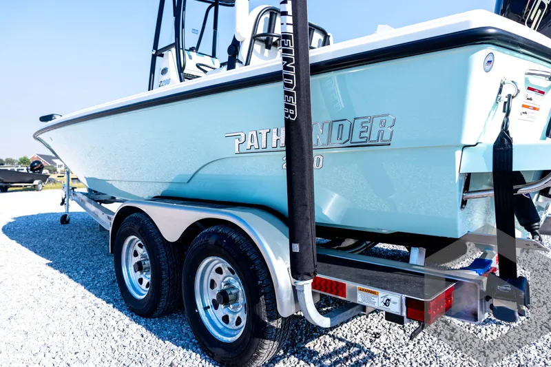 Slide: The Image of 2026 Pathfinder 2200 TRS boat on trailer, displayed outdoors on gravel. - 26